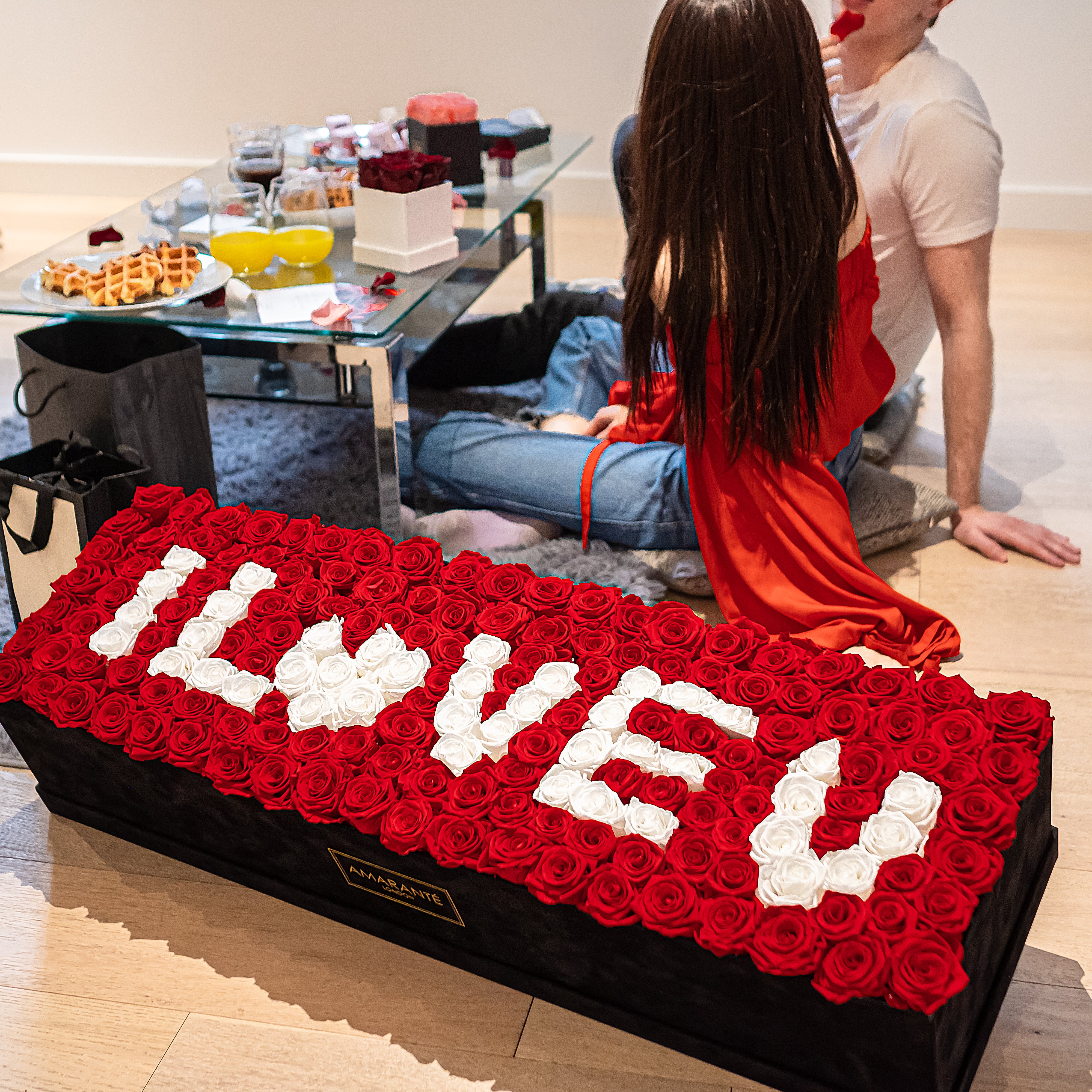 Captivating super deluxe black rectangular rose box, refined with a suede finish, housing 140 chic red and white infinity roses, symbolising enduring love with the phrase I LOVE YOU. Free UK delivery, Box size: 30"x25".