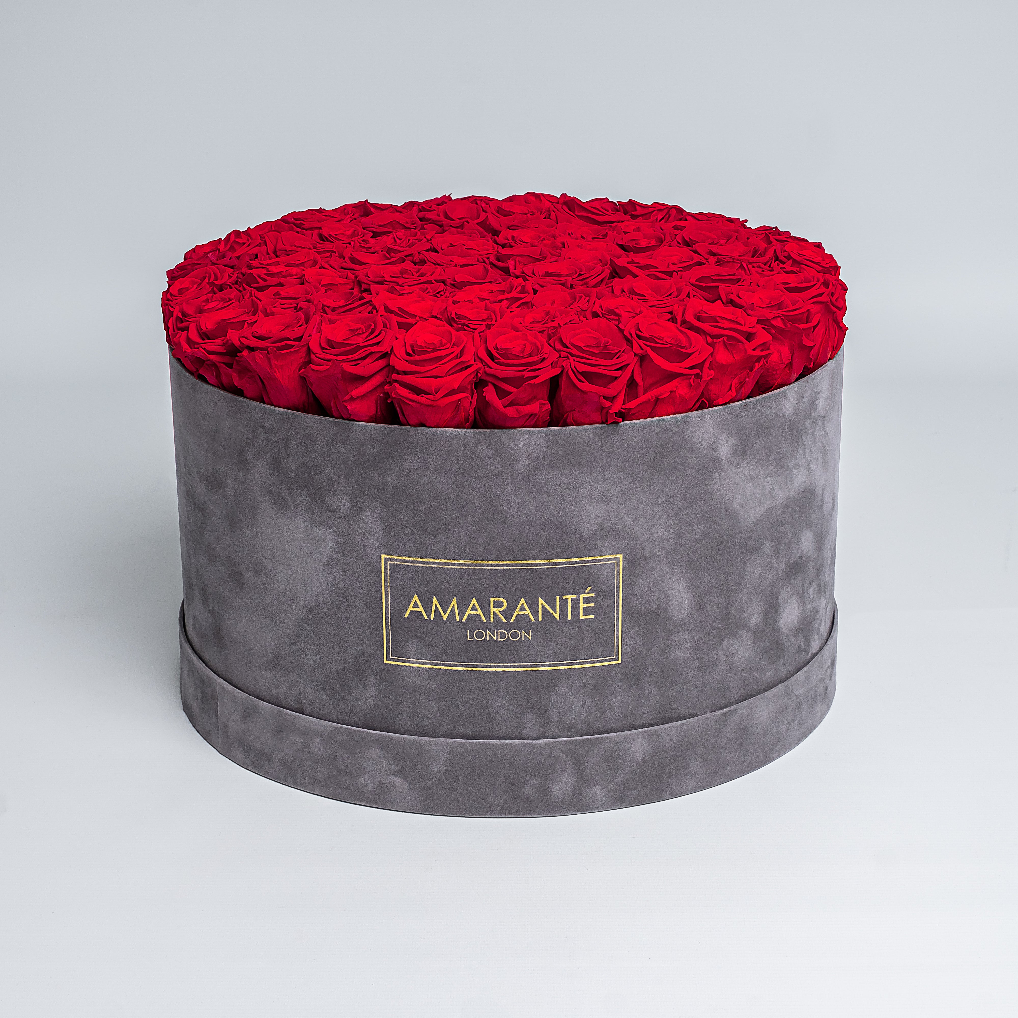Elegant light red Infinity Roses artistically arranged in a trendy round grey suede rose box. This mesmerising, luxurious gift can be delivered for free in the UK, perfect for showing timeless love and affection to family, friends, or your significant other.