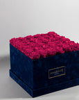 Majestic hot pink Roses in a dapper blue package, connoting playfulness, happiness, and joy. 