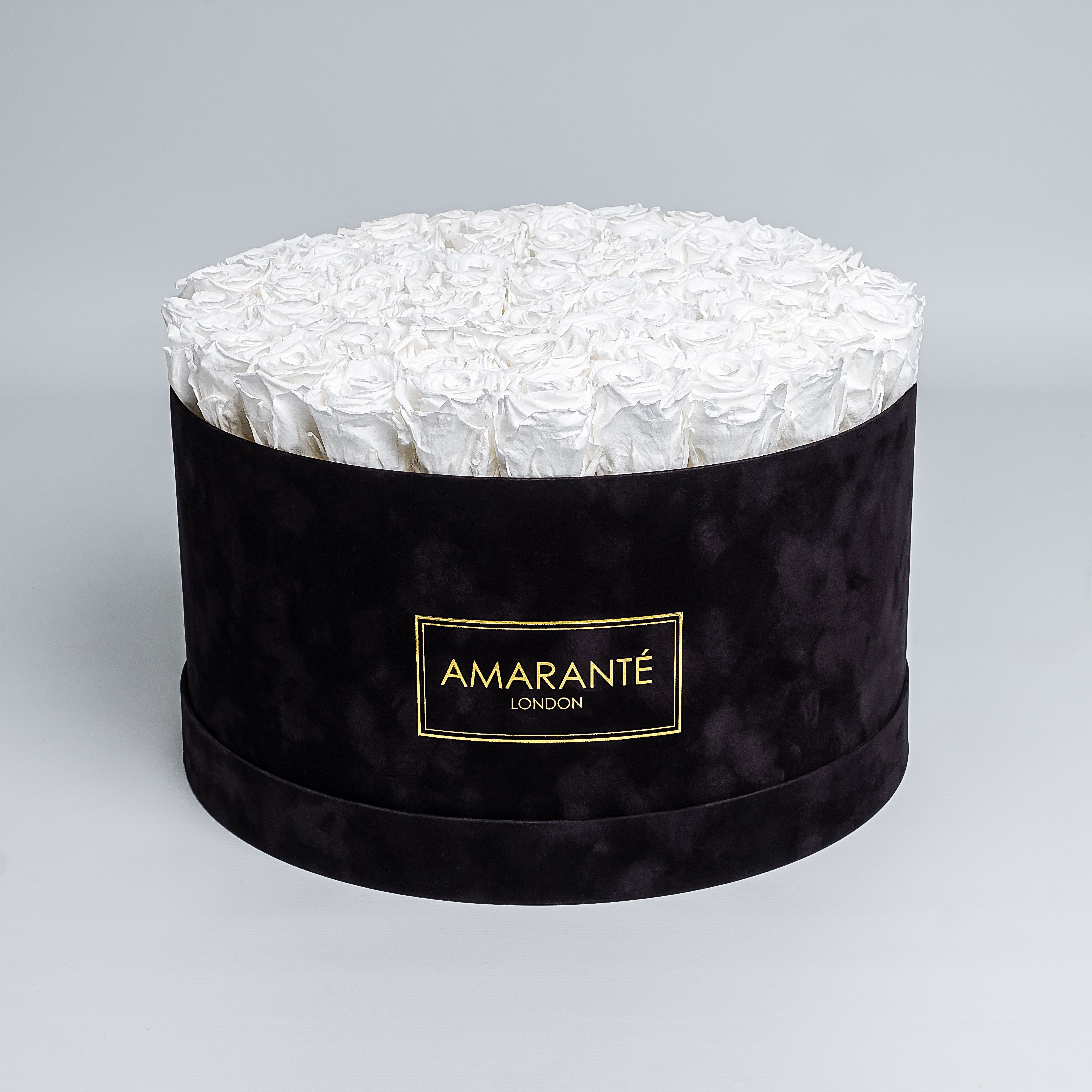 70 Exquisite pure white infinity roses elegantly arranged in a stylish black deluxe suede round rose box. Perfect for expressing timeless love and affection to family, friends and loved ones. Available for free UK delivery.