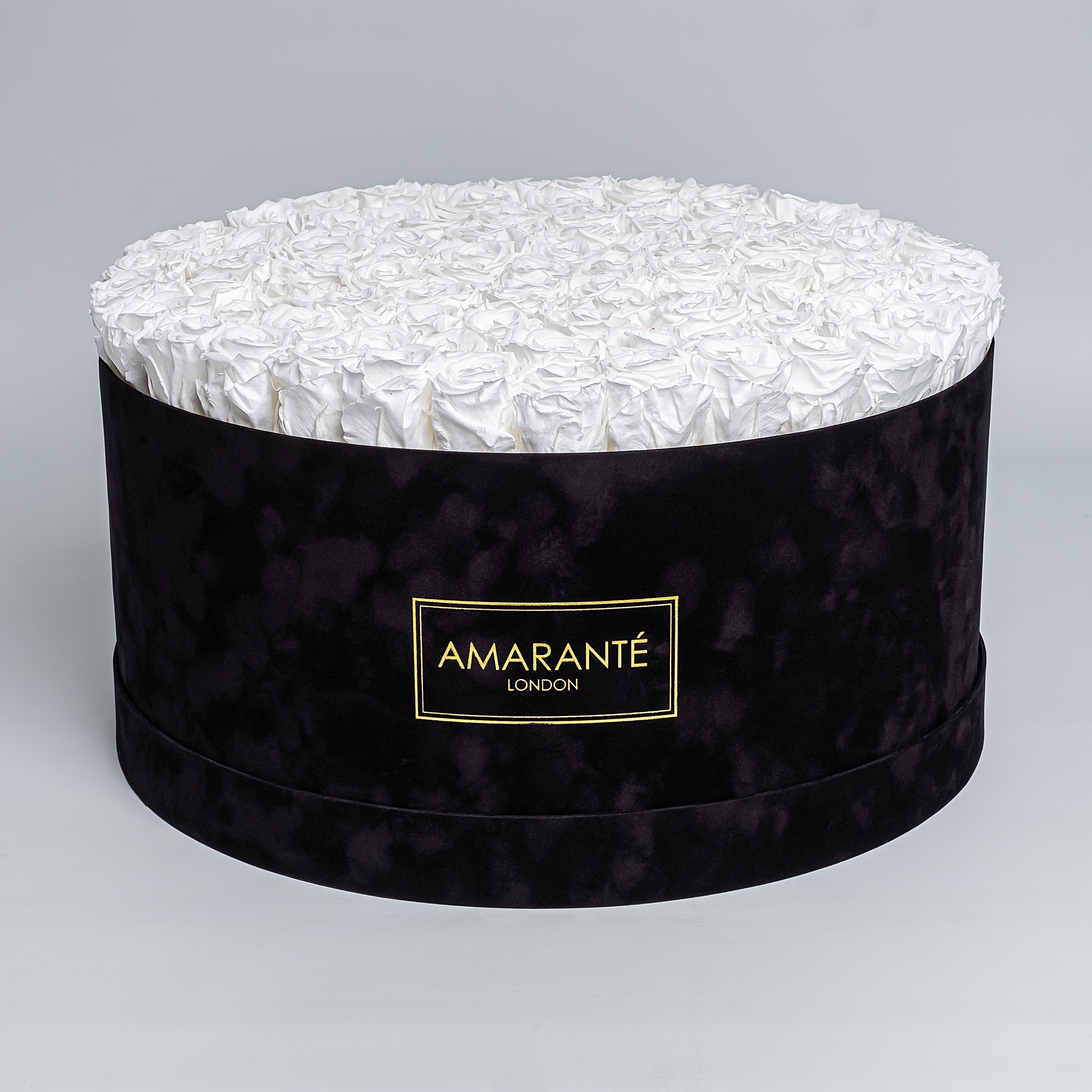 Elegant display of pure white forever roses in a chic black hatbox with delicate suede finish, symbolising enduring elegance and sophistication. Perfect for gifting to loved ones on Birthdays, Anniversaries, Valentine&#39;s Day or other special events of everyday life. Free UK delivery.