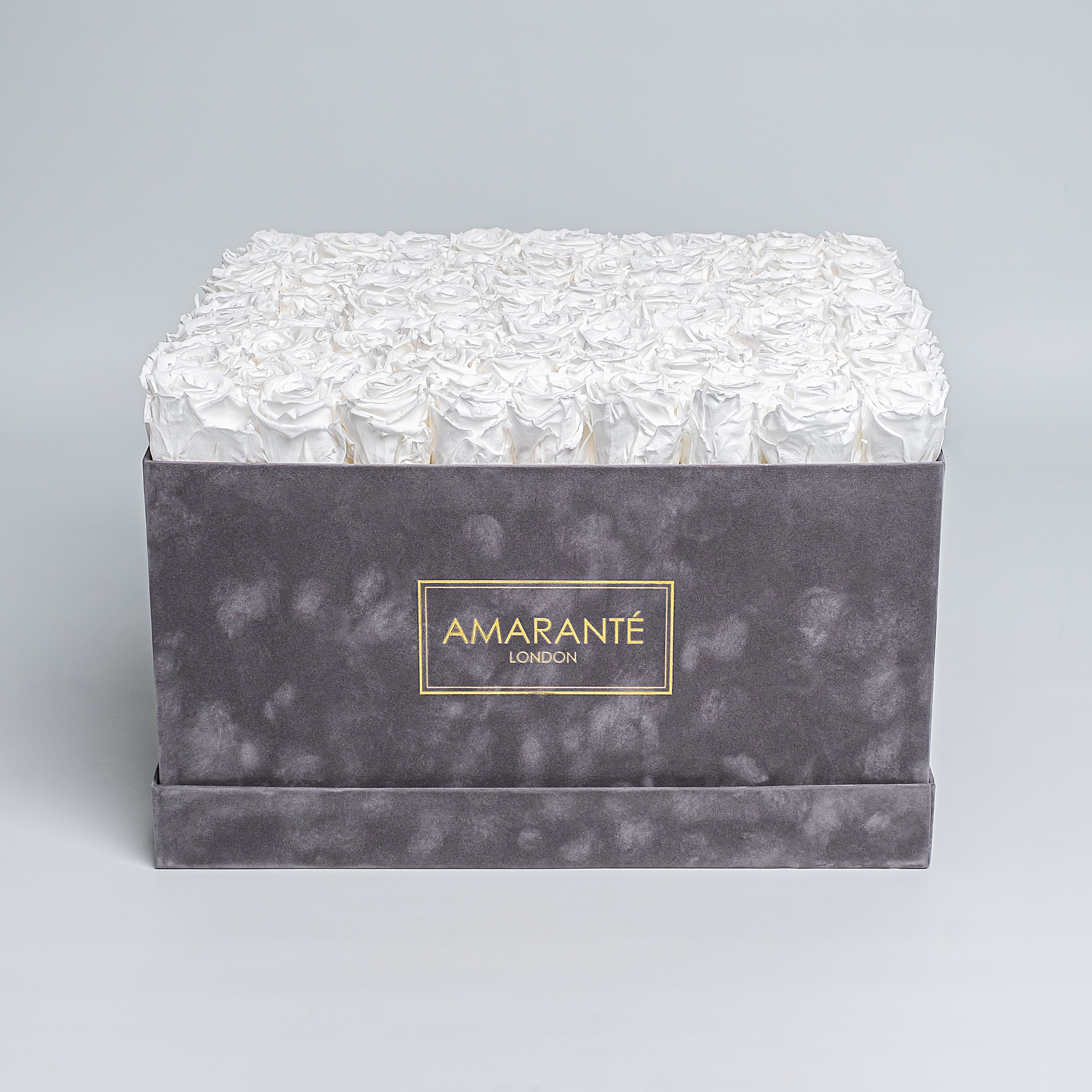 Elegant extra large grey suede hatbox with 100 large white infinity roses, a symbol of enduring love. Rose Box dimensions are 16"x16", with free UK delivery, choose your infinity roses from 14 exquisite colours - Amaranté London.