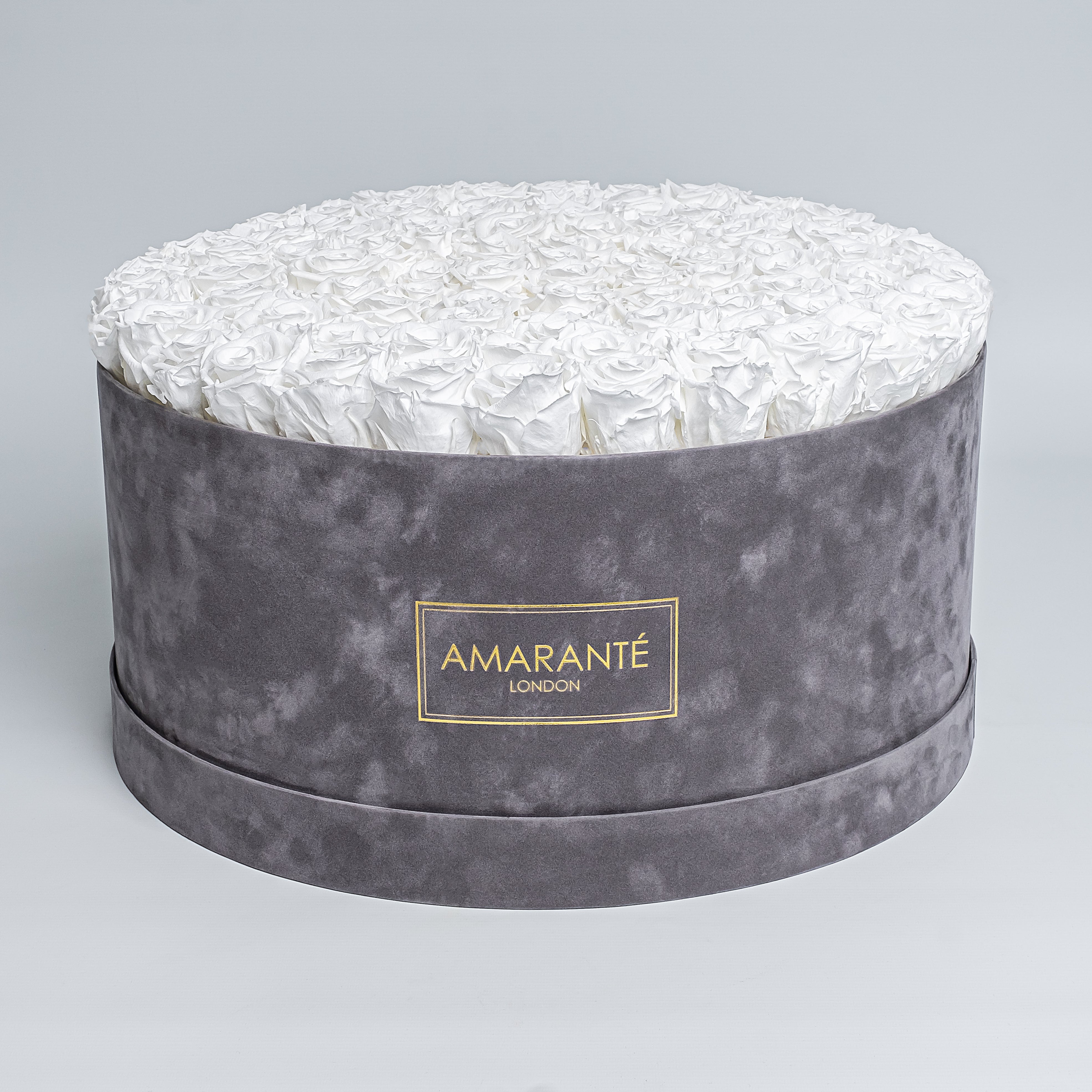 Elegant display of pure white forever roses in a chic grey hatbox with delicate suede finish, symbolising enduring elegance and sophistication. Perfect for gifting to loved ones on Birthdays, Anniversaries, Valentine&#39;s Day or other special events of everyday life. Free UK delivery.