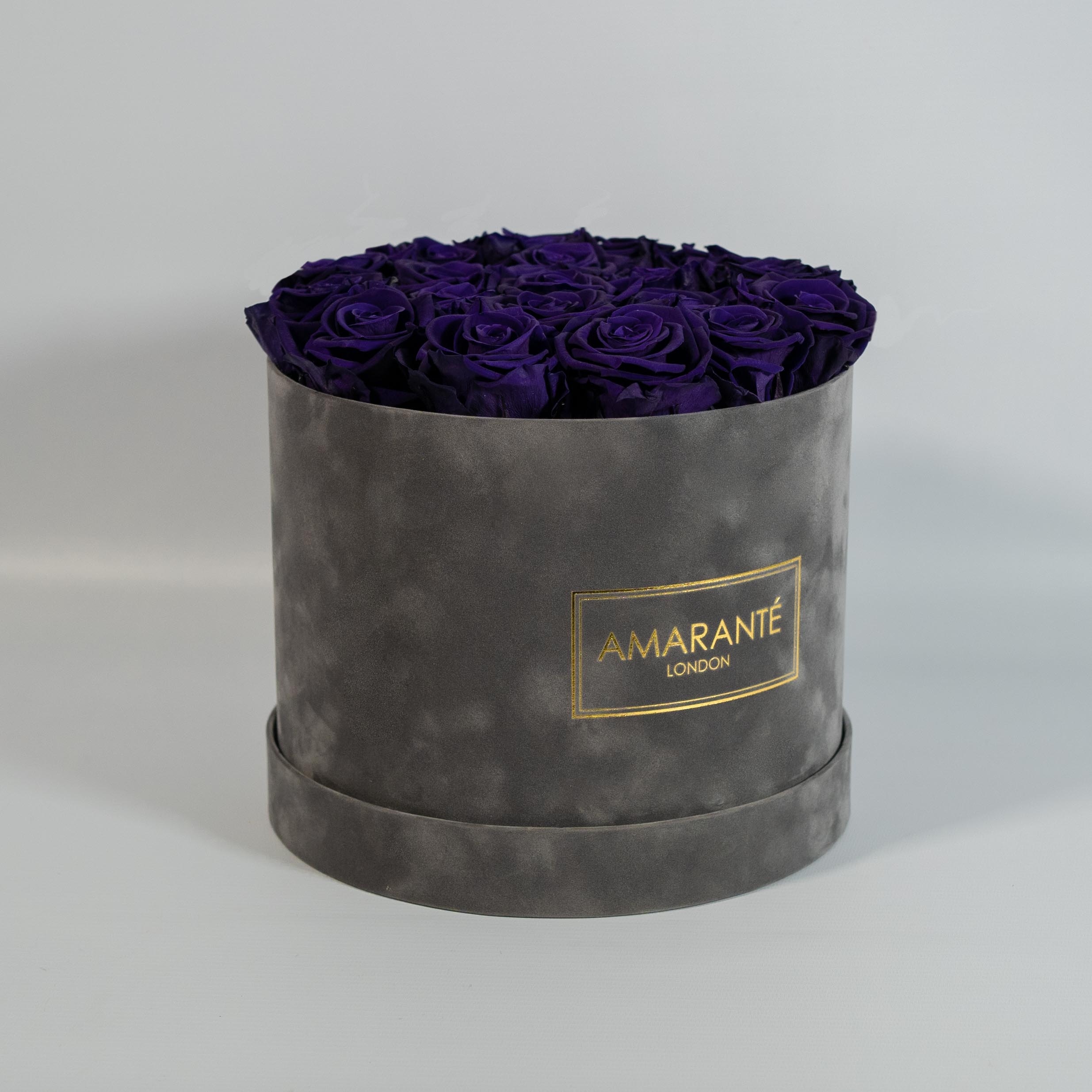 Charming dark purple Roses exhibited in a grey large round box 