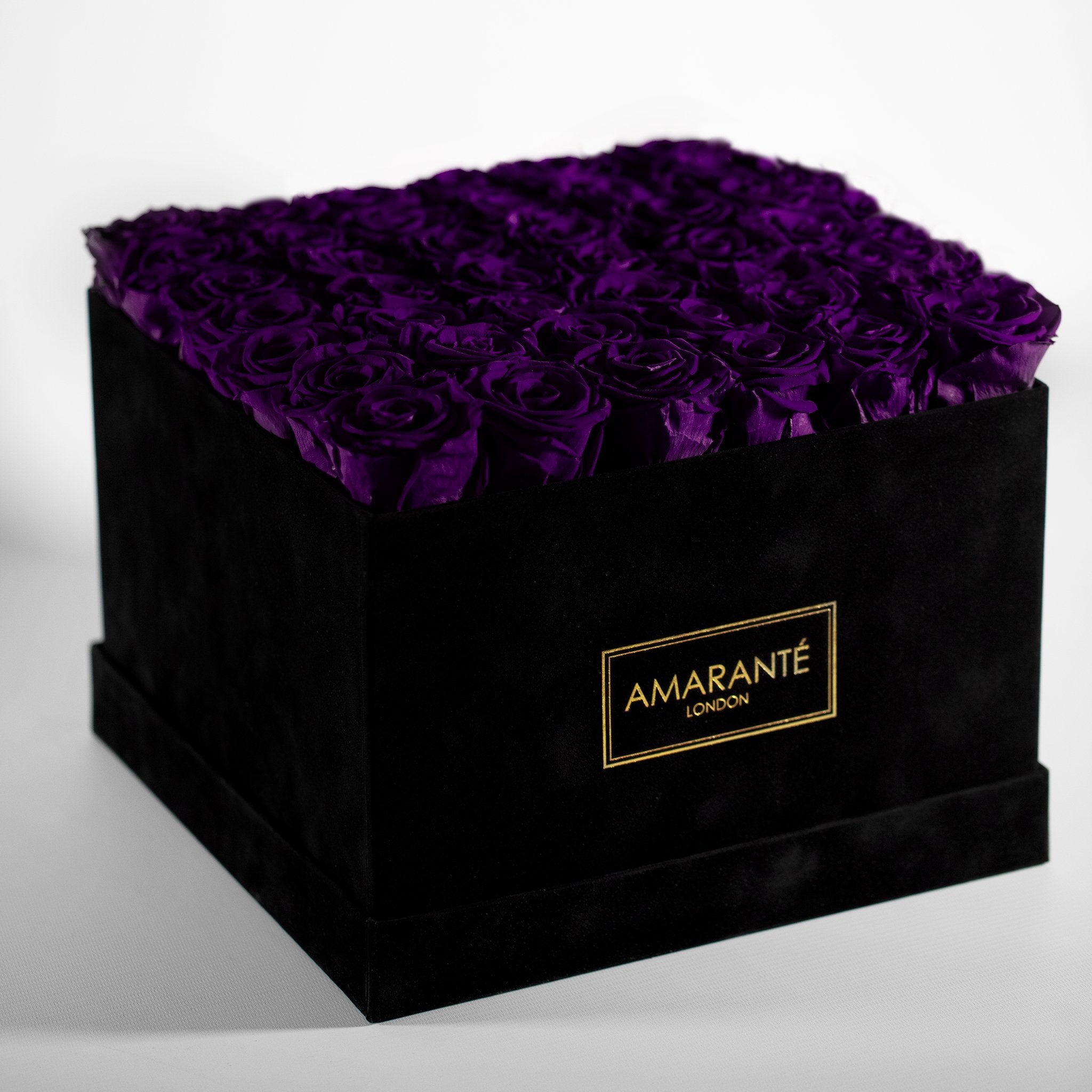 Timeless elegance captured by exquisite large purple forever roses in a chic black hatbox with elegant suede finish. Free UK Delivery.