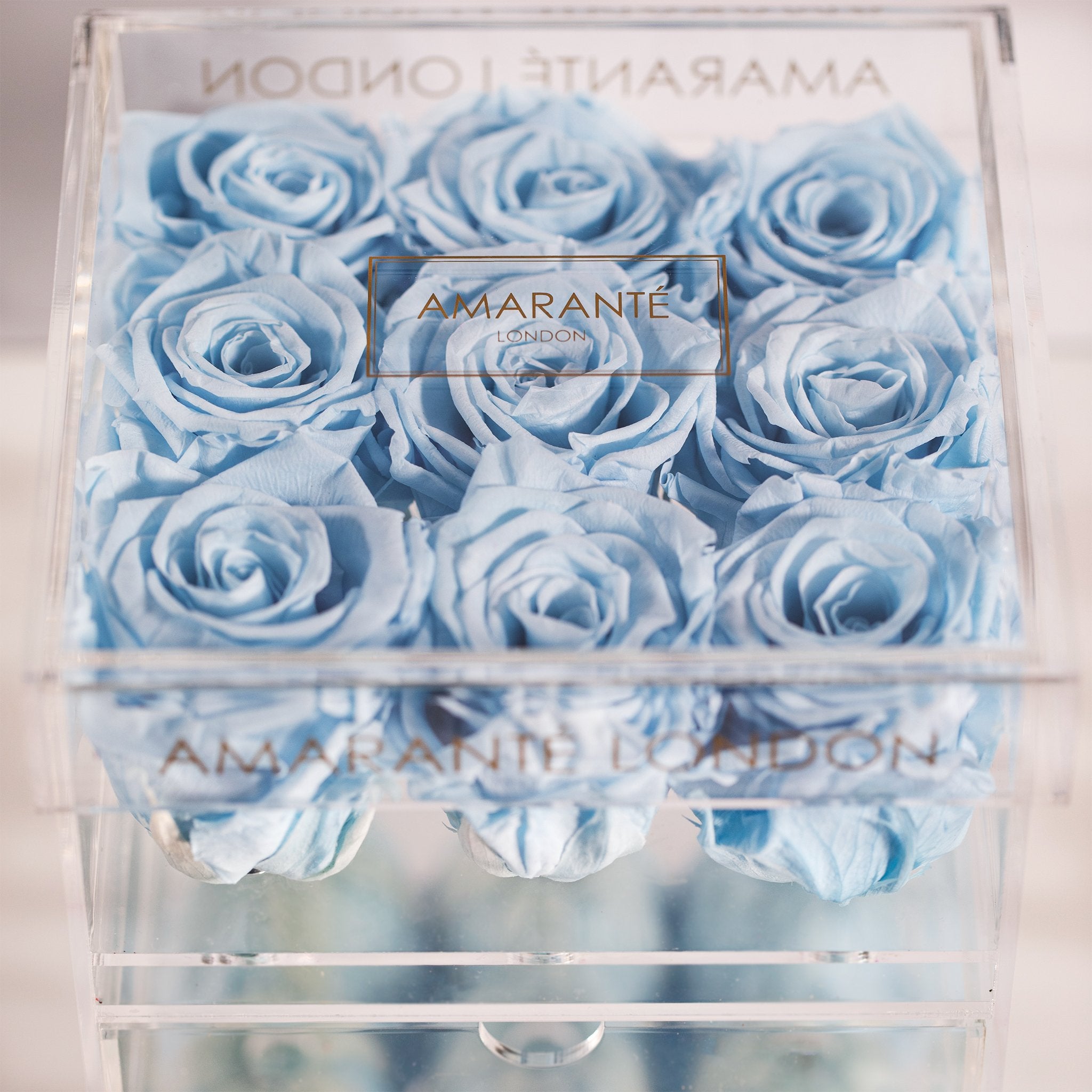 Cool light blue Roses displayed in a medium clear box 